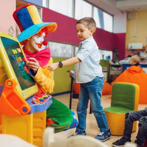 Clown with joyful children play in the alphabet